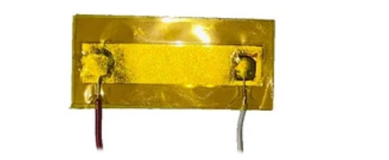 A shiny yellow sensor with a wire attached on each end
