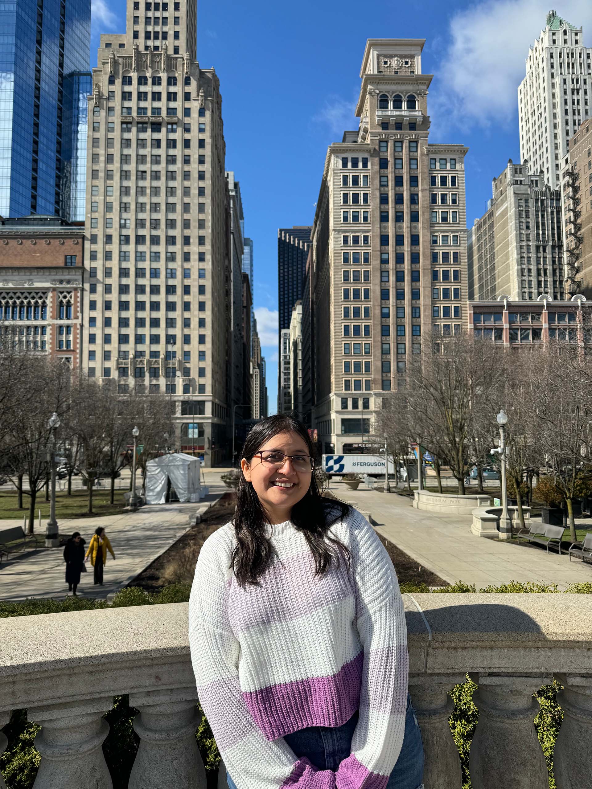 Abigail wearing a white sweater with a city backdrop