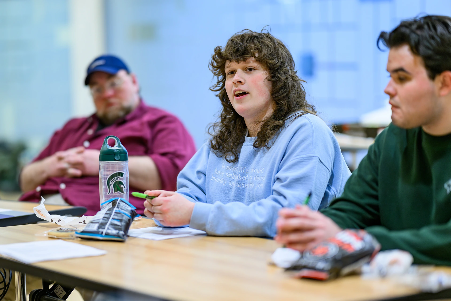 Student speaking while seated at a table